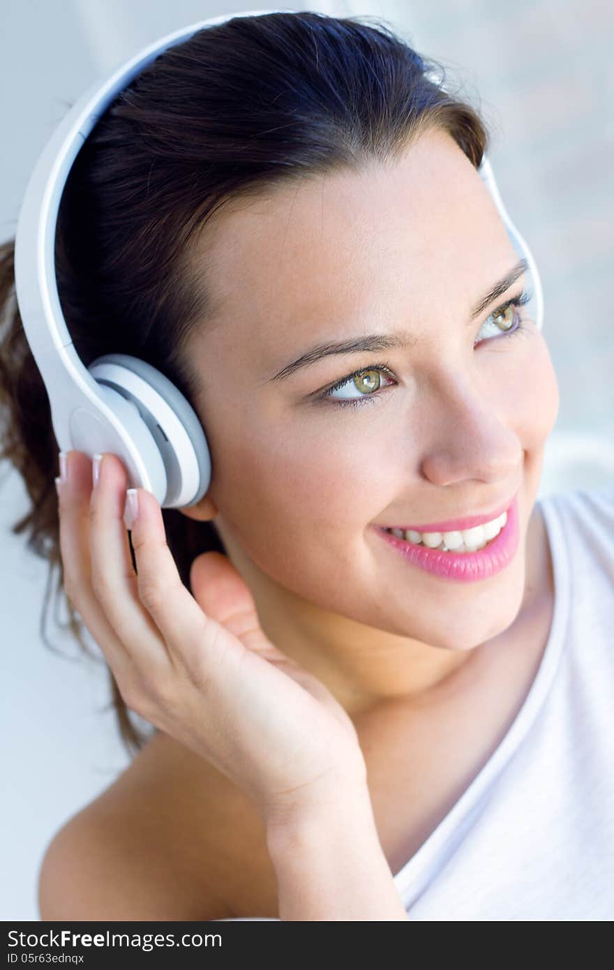 Pretty young woman listening music at home