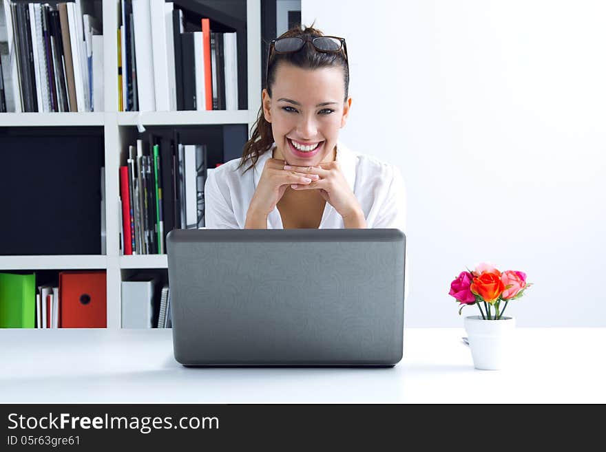 Beautiful young woman with laptop working at home