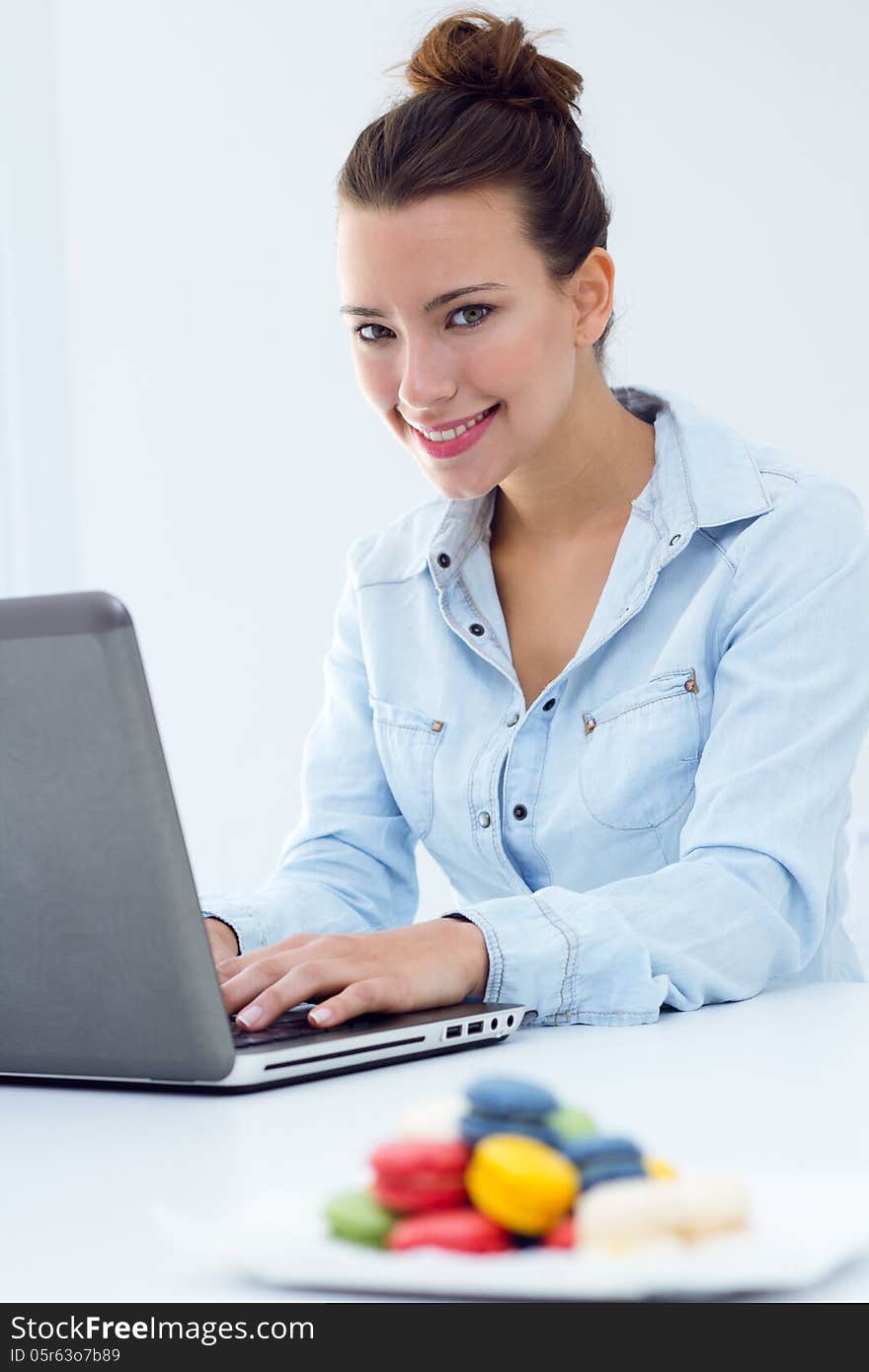 Beautiful young woman with laptop working at home