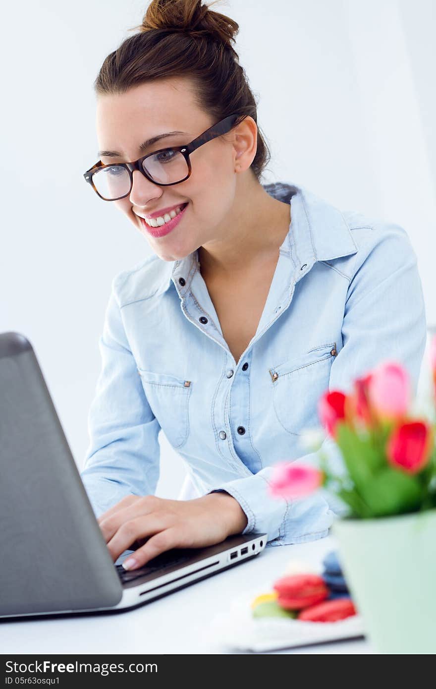 Beautiful young woman with laptop working at home