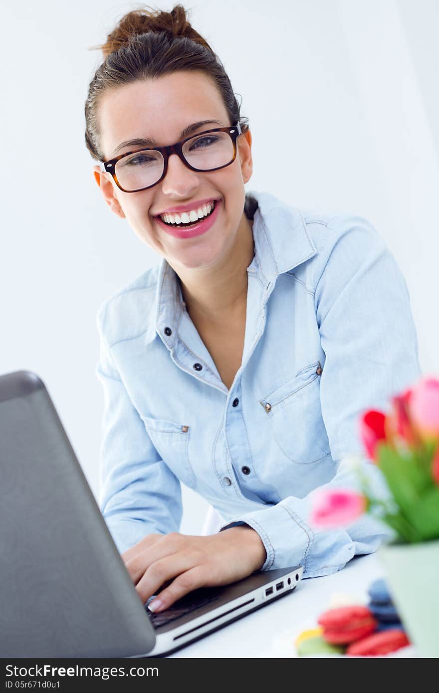 Beautiful young woman with laptop working at home