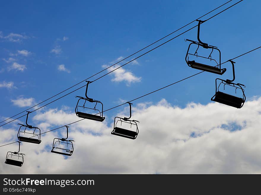 Chair lift, cableway on blue sky background