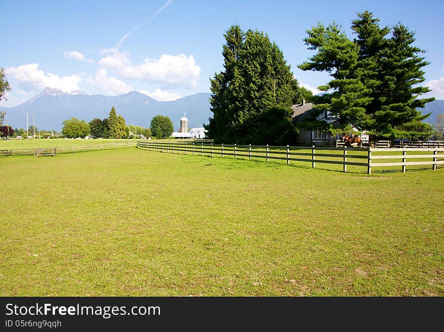 Landscape of farm land set against Coastal BC mountains in Chilliwack BC.