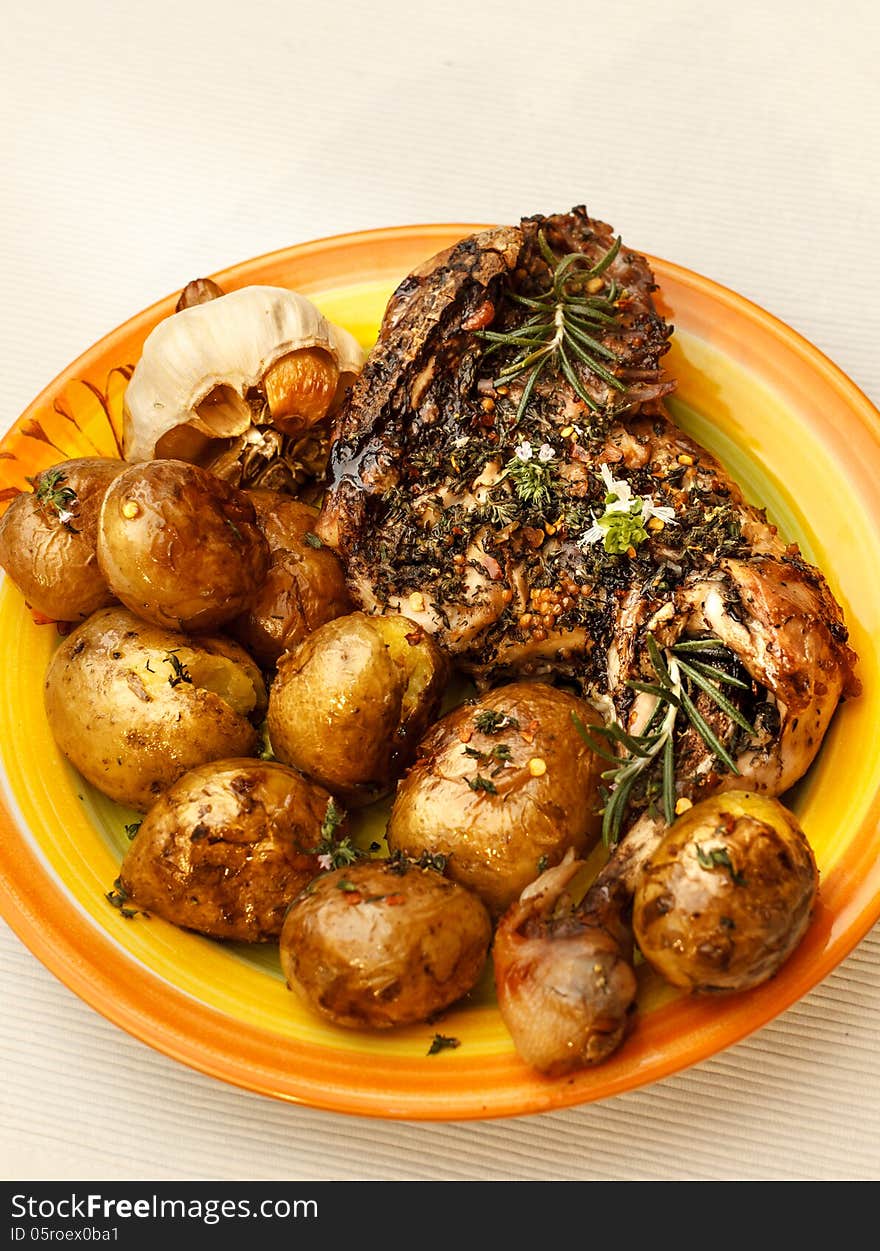 Roasted chicken leg with potatoes and herbs. Roasted chicken leg with potatoes and herbs