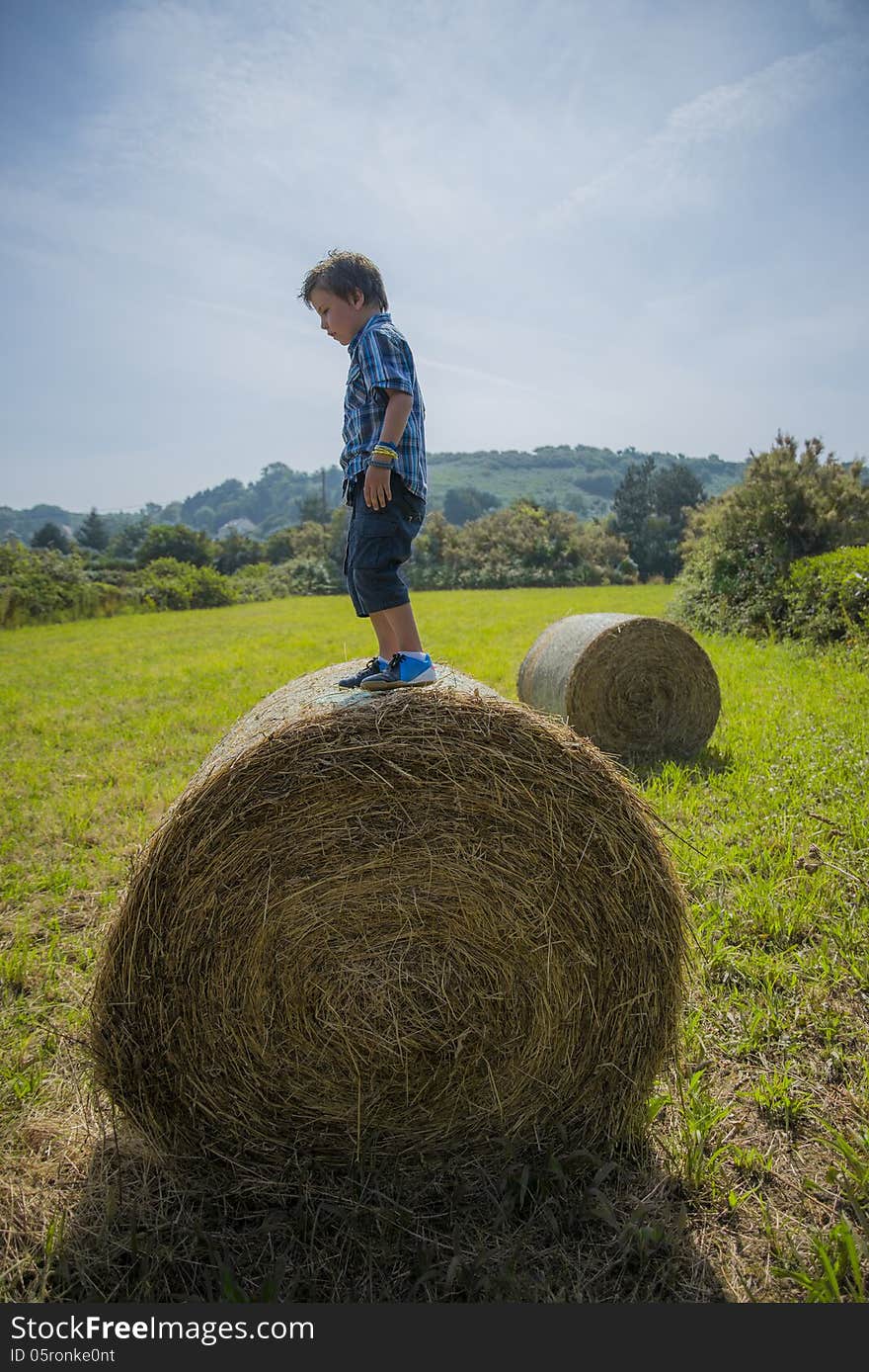 Boy On Round Hay Bale