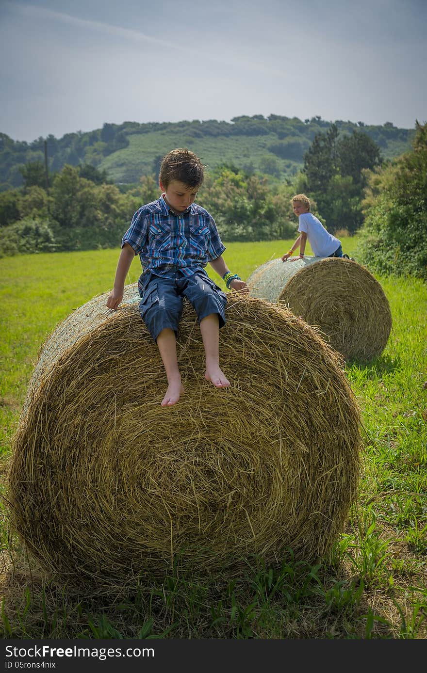 Boys on round hay bales