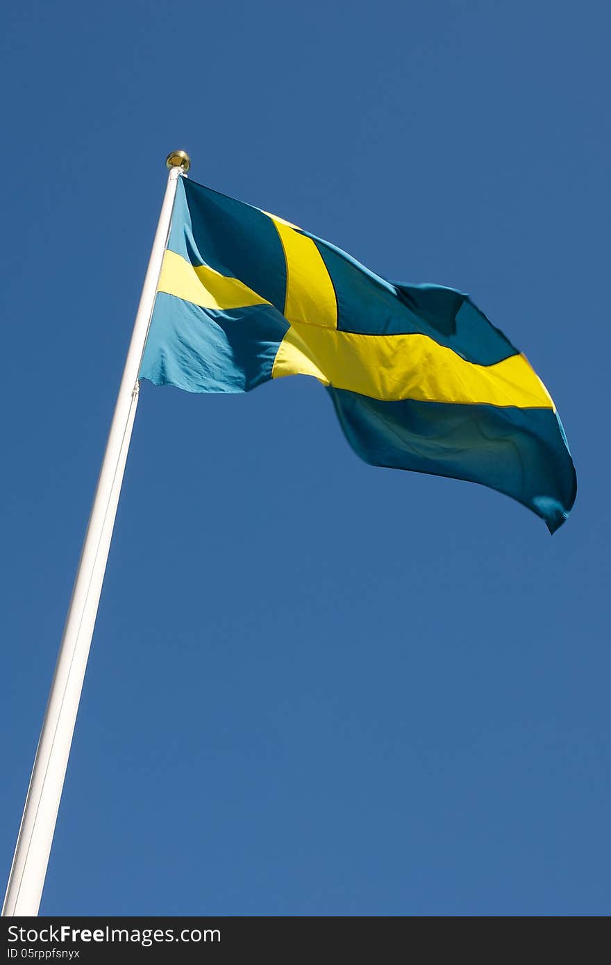 Picture of Swedish flag waving in the wind, on a blue sky  Picture of Swedish flag waving in the wind, on a blue sky