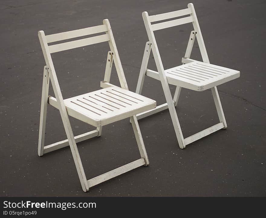 Two white folding chairs