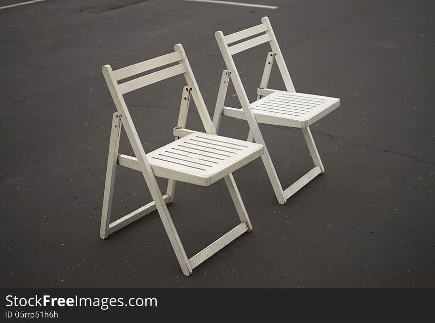 Two white folding chairs