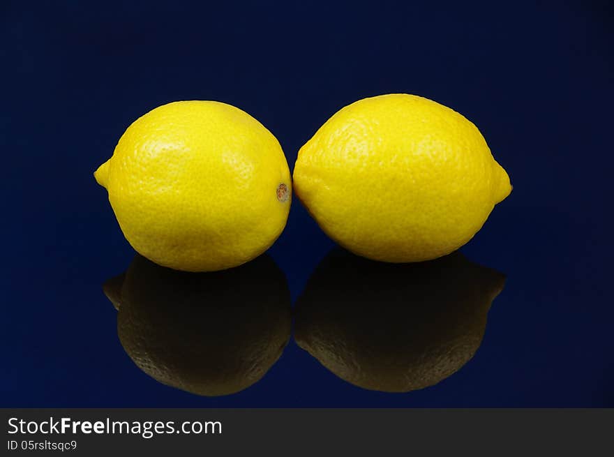 Photo shows the fruits of lemon placed on a blue background. Photo shows the fruits of lemon placed on a blue background.