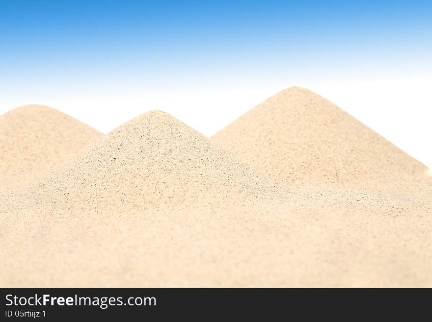 Several sandy hills against the blue sky