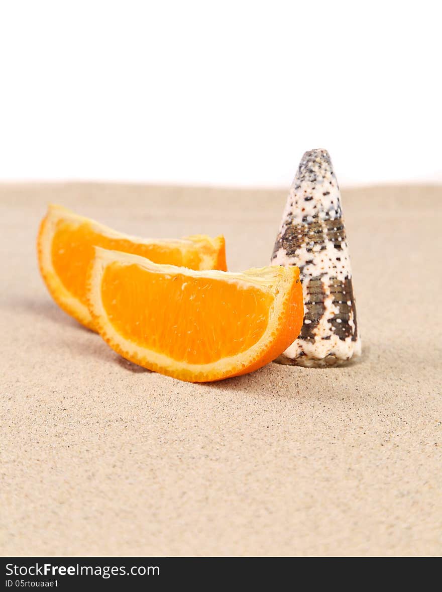 Orange and shell on sand. White background.