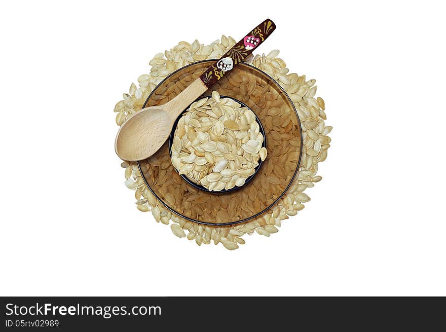 Plate of filled with pumpkin seeds stands on pumpkin seeds