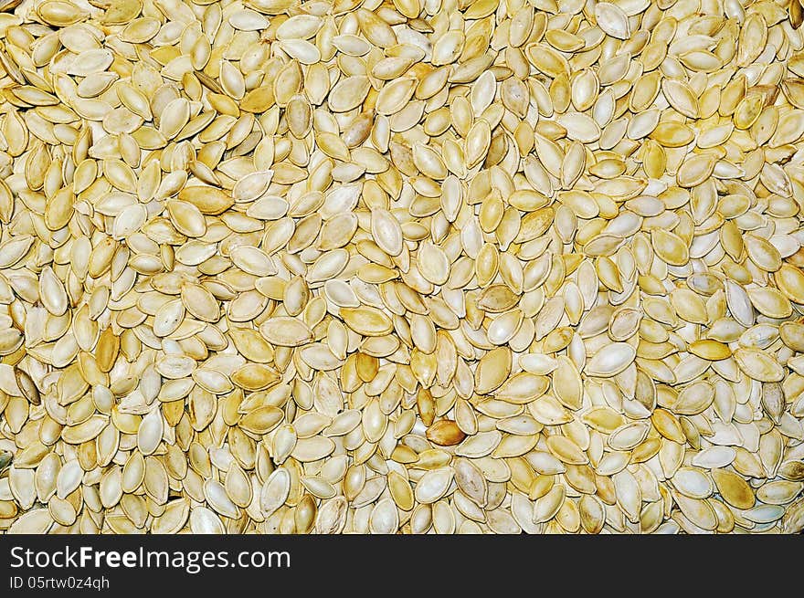 Plate of filled with pumpkin seeds stands on pumpkin seeds