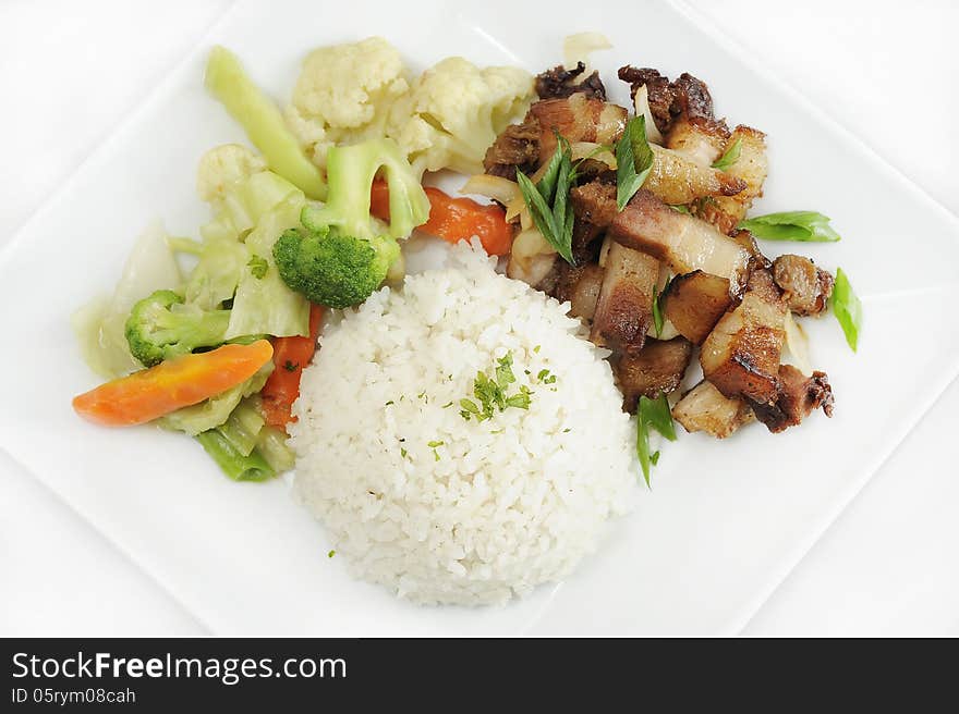 Fried pork chop, steamed vegetables and rice shot on a plate on a white background. Fried pork chop, steamed vegetables and rice shot on a plate on a white background