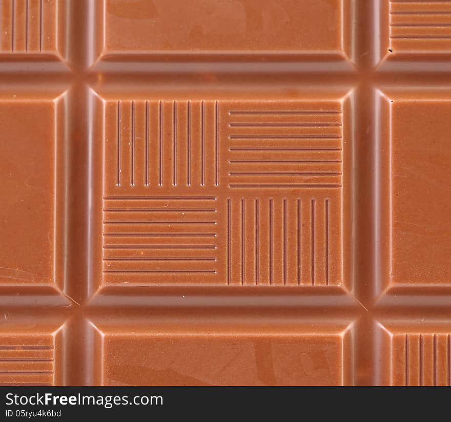 Milk chocolate bar as background.