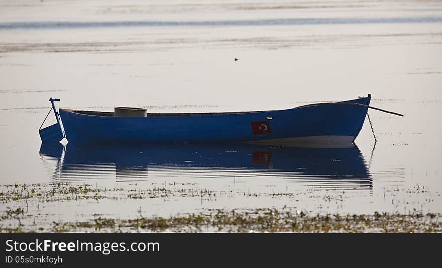 A blue empty boat floating on the lake. A blue empty boat floating on the lake