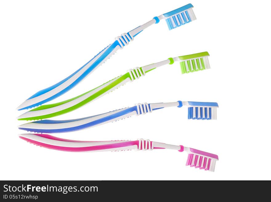 Four new multi-colored toothbrushes are on a white background