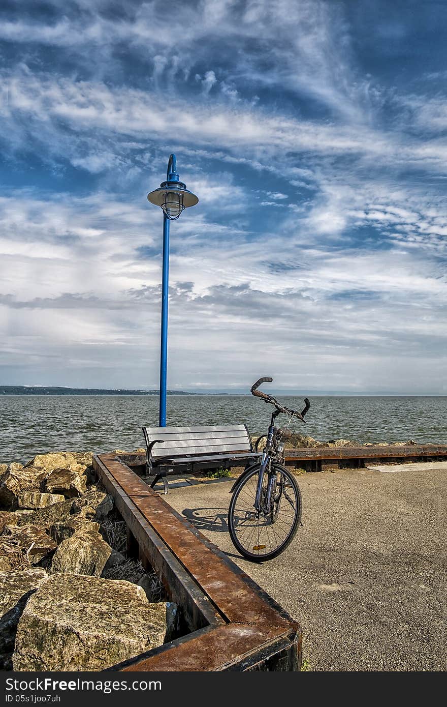 Bicycle on a quay with a lamppost on nice sunny afternoon