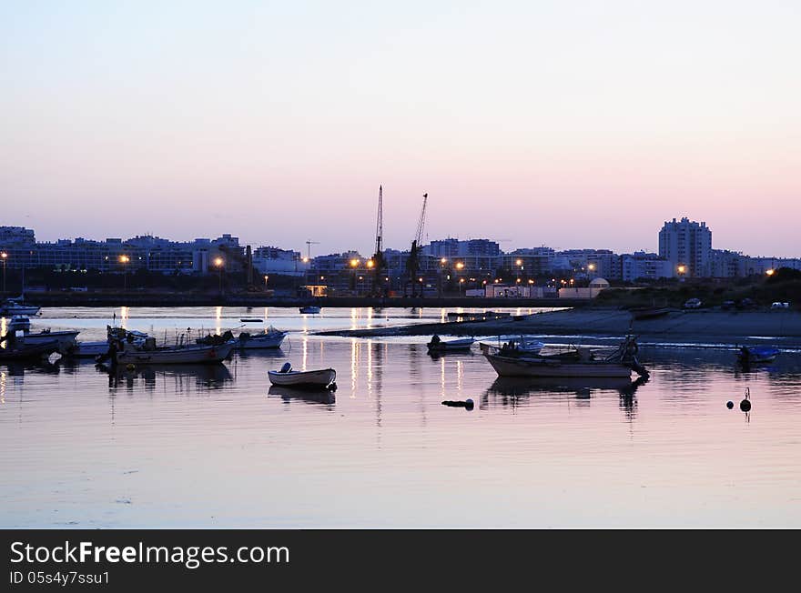 Ferragudo at dusk, Algarve, Portugal. Cranes on the horizon.