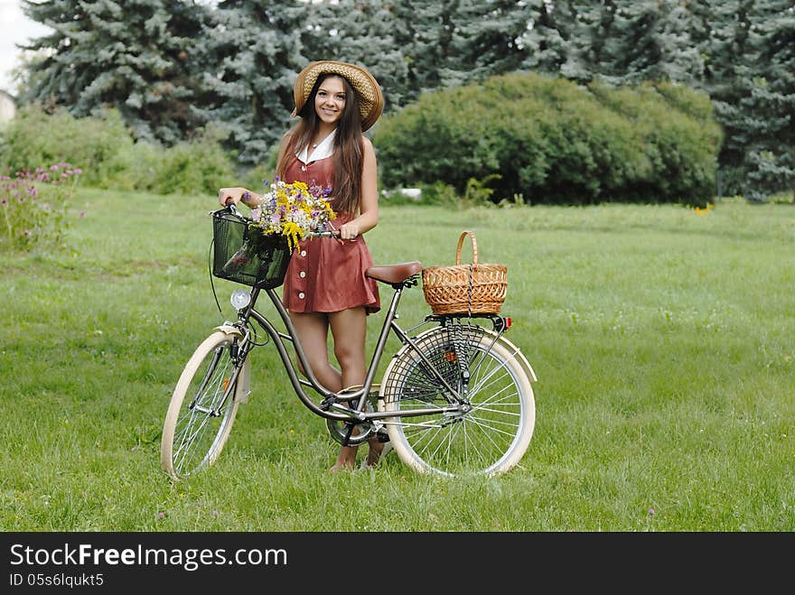 Fashion portrait of young pretty woman with bicycle and flowers