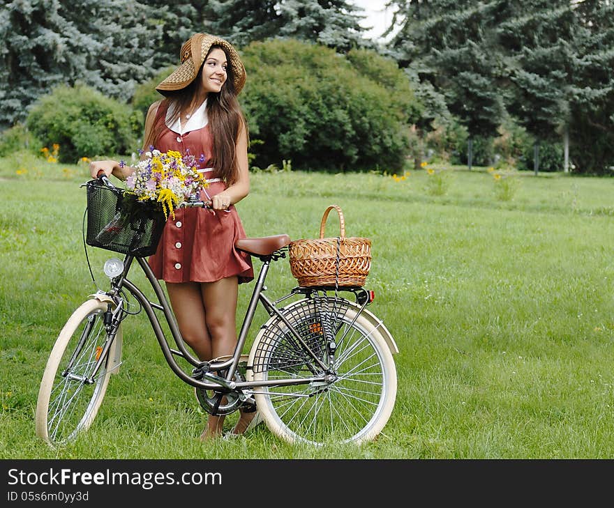 Fashion portrait of young pretty woman with bicycle and flowers