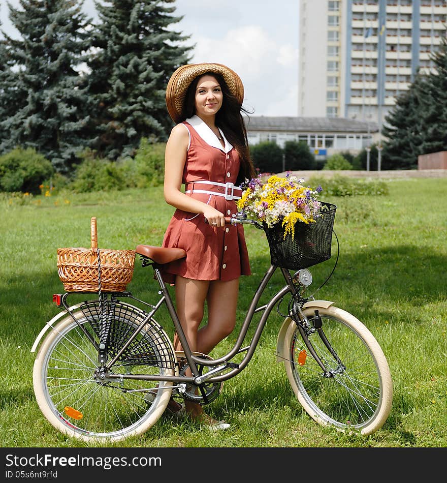 Fashion portrait of young pretty woman with bicycle and flowers