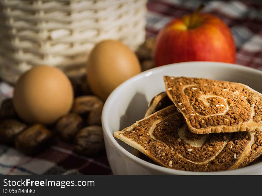 Cookies, apple and eggs with basket on the cloth. Cookies, apple and eggs with basket on the cloth