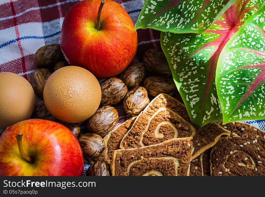 Cookies, apple and eggs with leaf on the cloth. Cookies, apple and eggs with leaf on the cloth