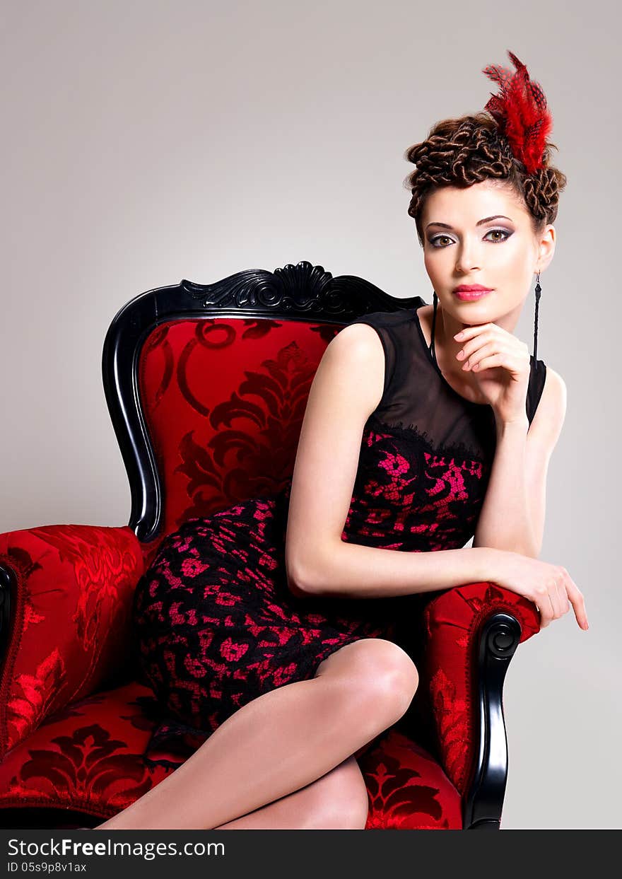 Woman with fashion hairstyle and red armchair