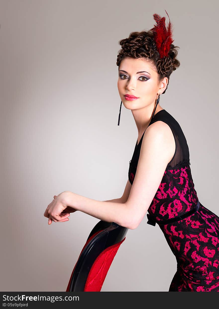 Woman with fashion hairstyle and red armchair