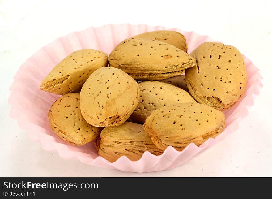 A small paper cup of almonds in the shell.