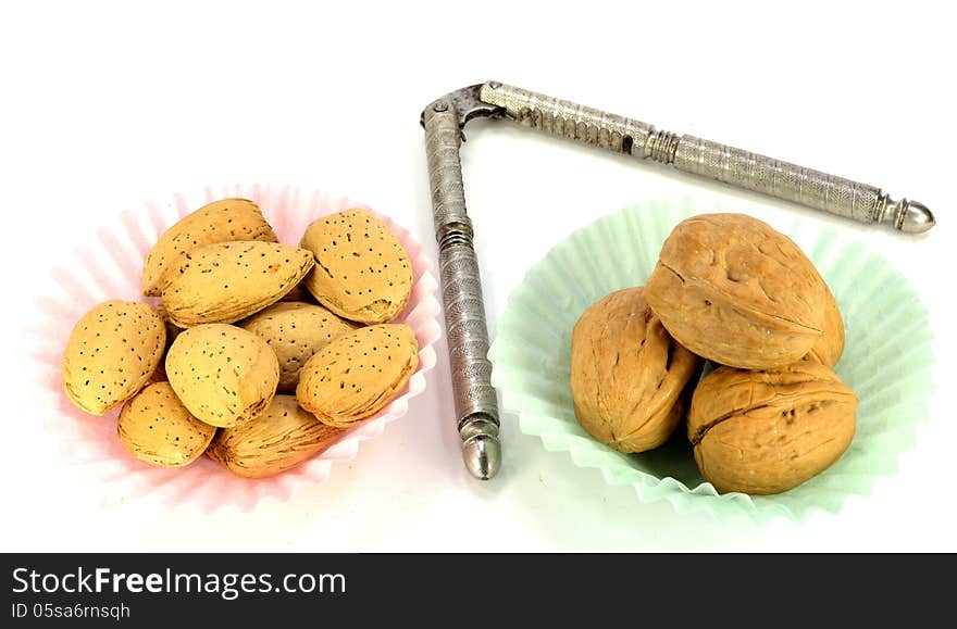 Walnut and almonds in paper cups with a nutcracker. Walnut and almonds in paper cups with a nutcracker.