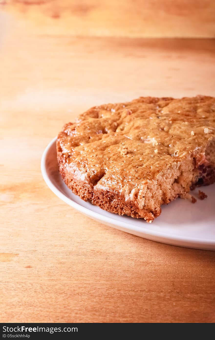 Homemade cake with cut piece on a wooden table