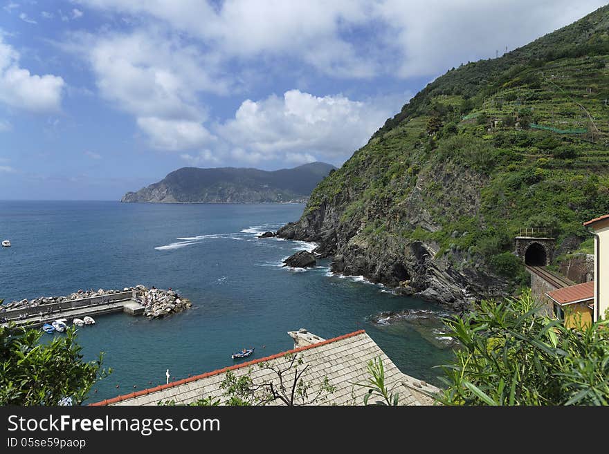 Vernazza is a town and comune located in the province of La Spezia, Liguria, northwestern Italy. It is one of the five towns that make up the Cinque Terre region. Vernazza is the fourth town heading north, has no car traffic, and remains one of the truest fishing villages on the Italian Riviera. In 1997 Vernazza was recognized as a UNESCO World Heritage Site. On the photo one can see the railway line that links the settlements of the Chinque Terre. Vernazza is a town and comune located in the province of La Spezia, Liguria, northwestern Italy. It is one of the five towns that make up the Cinque Terre region. Vernazza is the fourth town heading north, has no car traffic, and remains one of the truest fishing villages on the Italian Riviera. In 1997 Vernazza was recognized as a UNESCO World Heritage Site. On the photo one can see the railway line that links the settlements of the Chinque Terre.