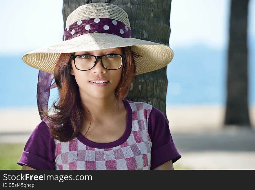 Portrait of a cute Asian girl in a hat on a background of the sea