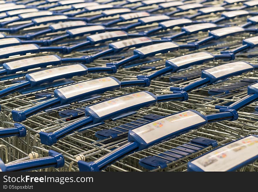 Metal shopping trolley stack with blue plastic hand grip