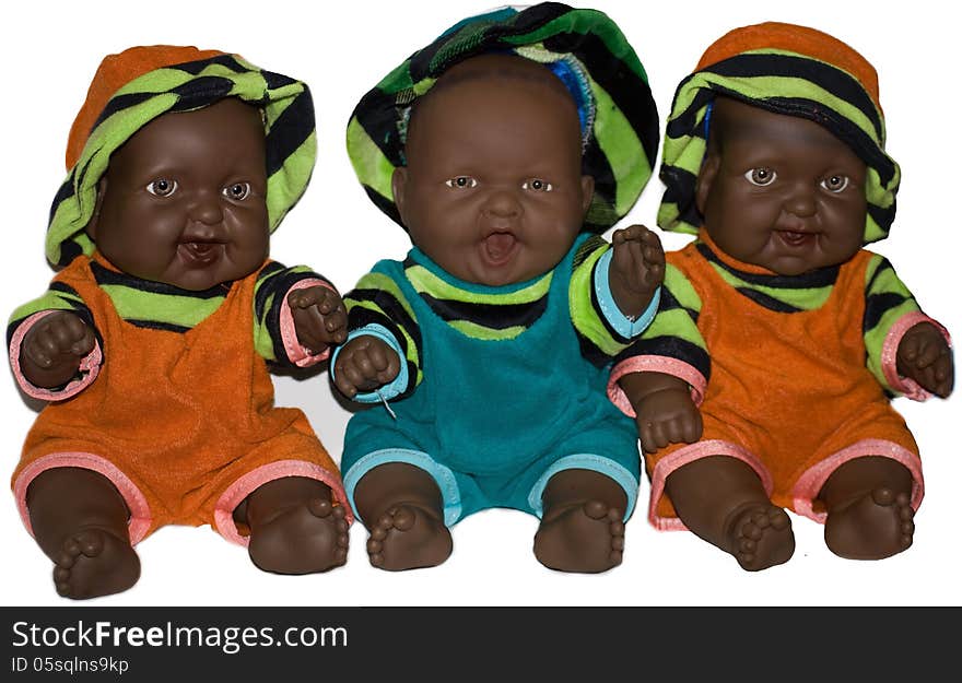 Three dark-skinned colorfully dressed smiling baby dolls. Three dark-skinned colorfully dressed smiling baby dolls.