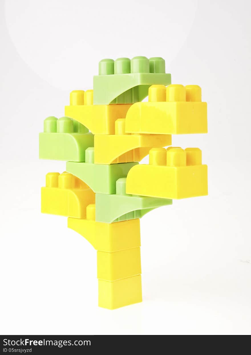 Green and yellow block toy in tree figure on white background. Green and yellow block toy in tree figure on white background