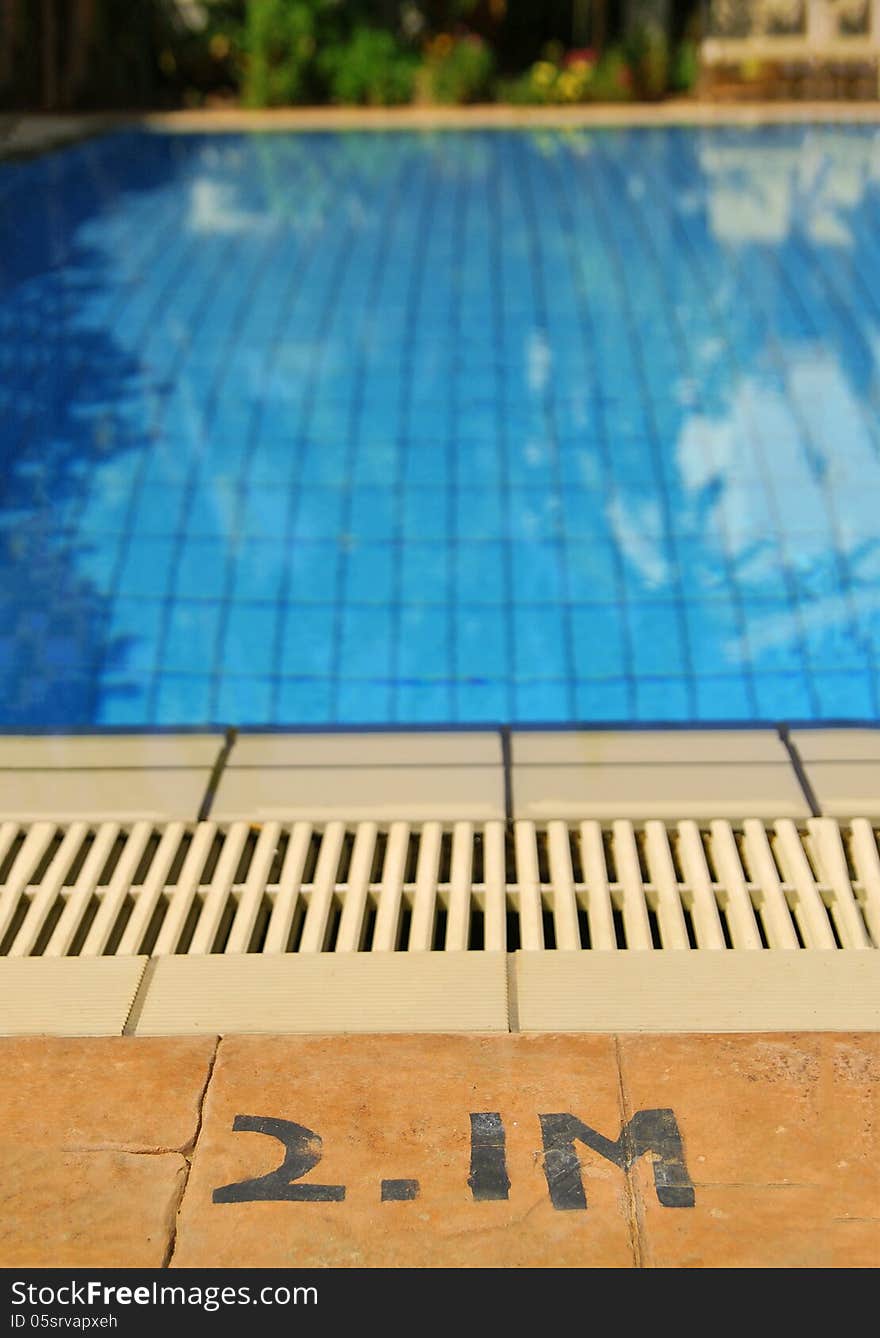 Close up of the edge of swimming pool and sign indicating the depth of the pool. Close up of the edge of swimming pool and sign indicating the depth of the pool