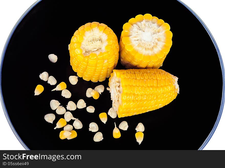 The divided boiled corn on black plate