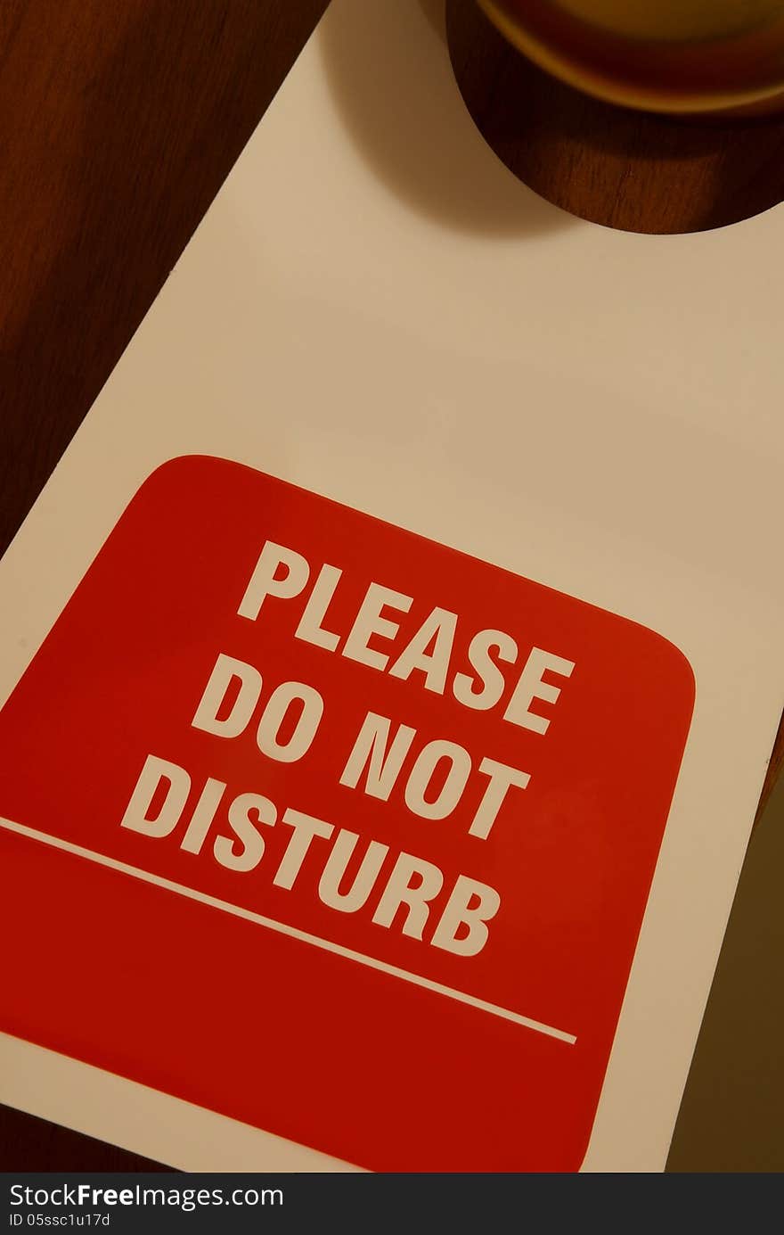 Signboard hanging on a door written: please do not disturb. Signboard hanging on a door written: please do not disturb