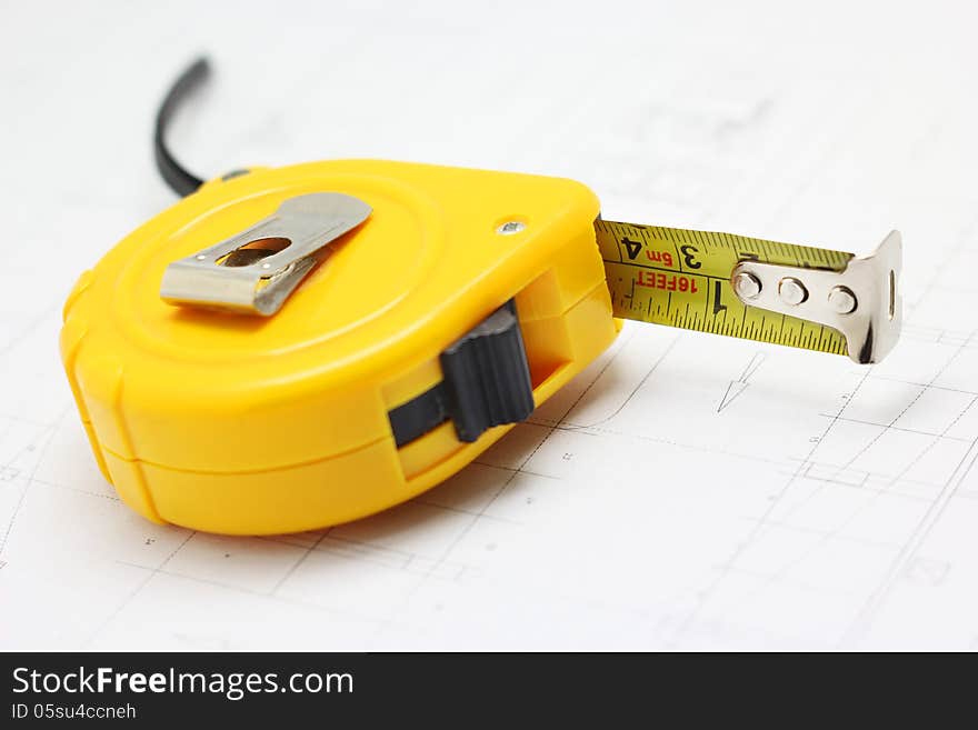 Measuring tape on floor plan background