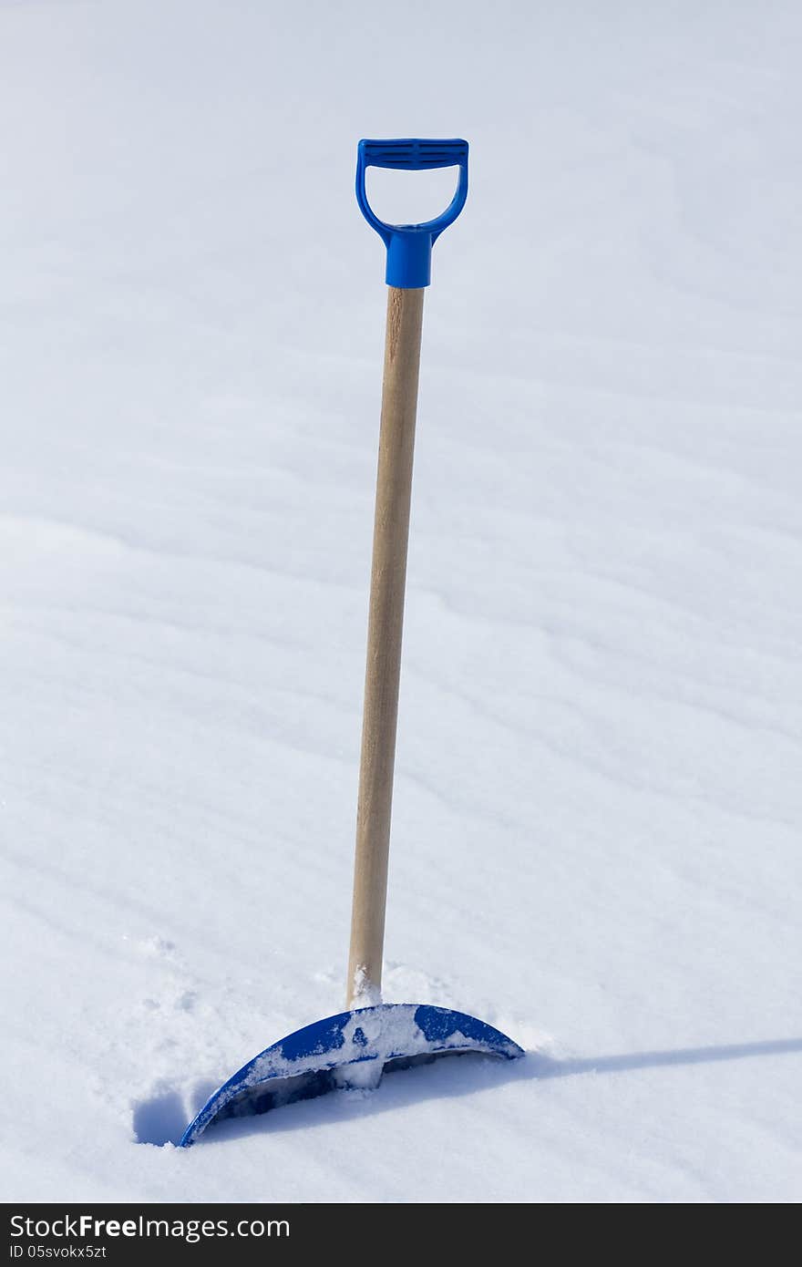 Snow shovel standing in the snow