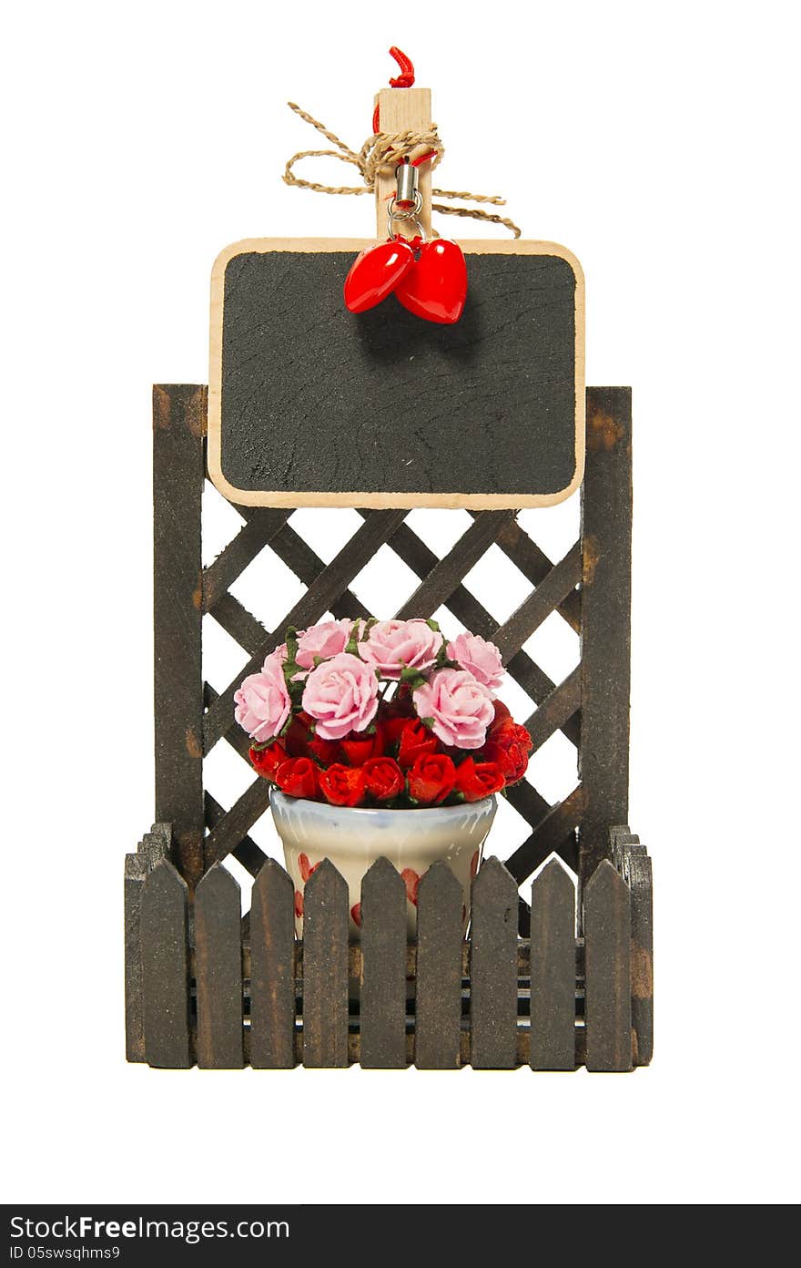 Small black board on the fence with roses and heart shapes