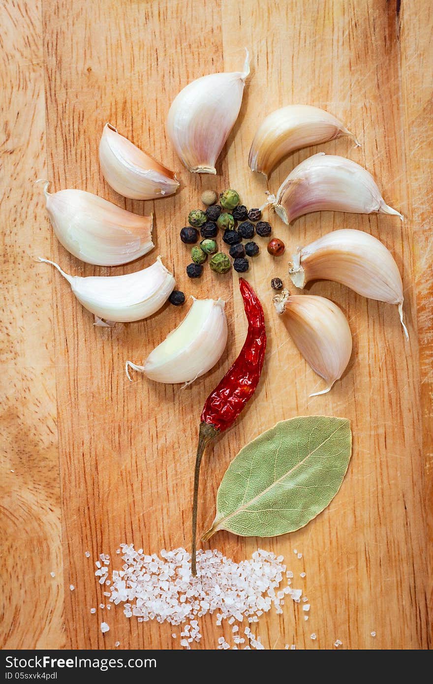 Various spices in form of flower on old chopping board