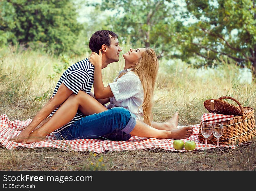 Young Couple On Picnic, Sitting Face To Fa