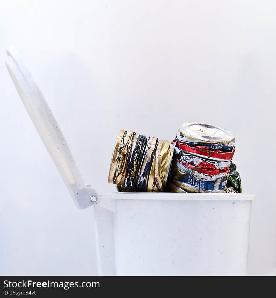 Crushed beverage cans in trash can, on white. Crushed beverage cans in trash can, on white