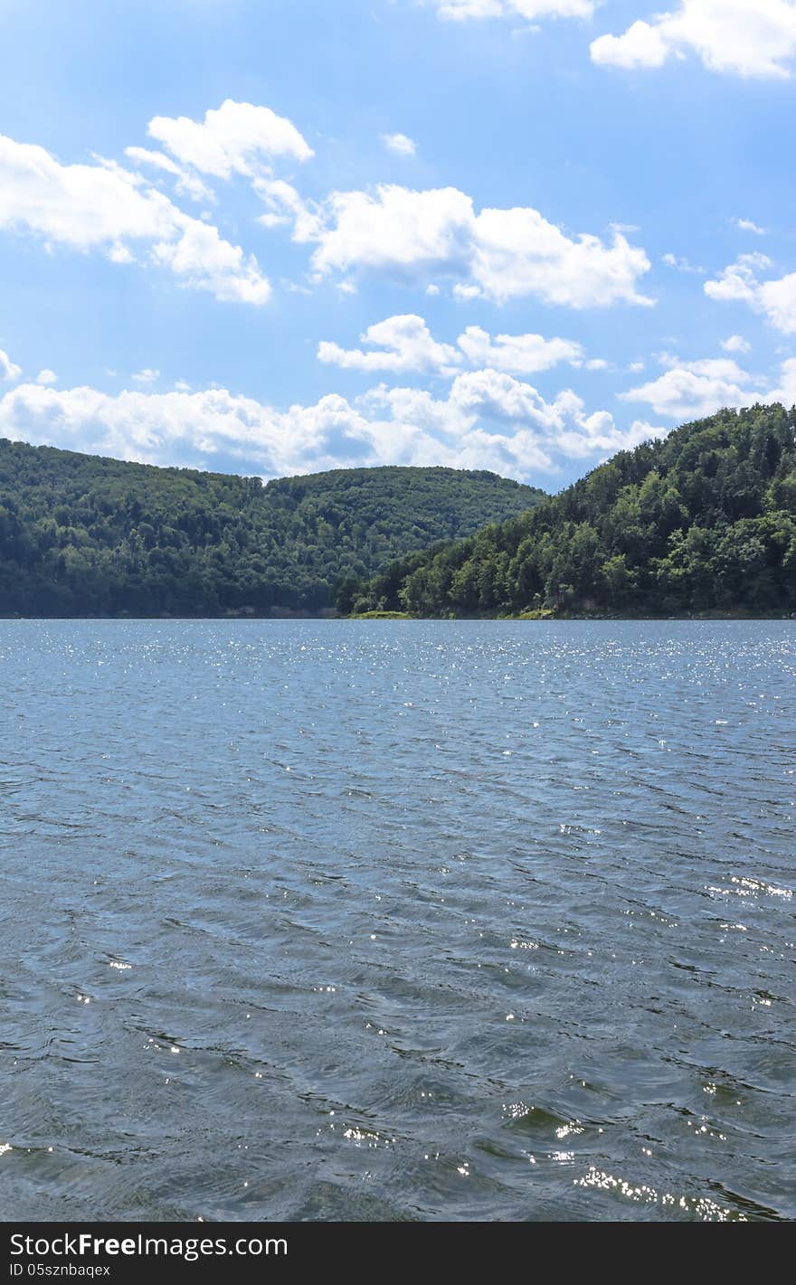 Sunny day on the lake in Poland. The artificial lake is located in the low mountains amidst the beautiful and wild forests. Sunny day on the lake in Poland. The artificial lake is located in the low mountains amidst the beautiful and wild forests