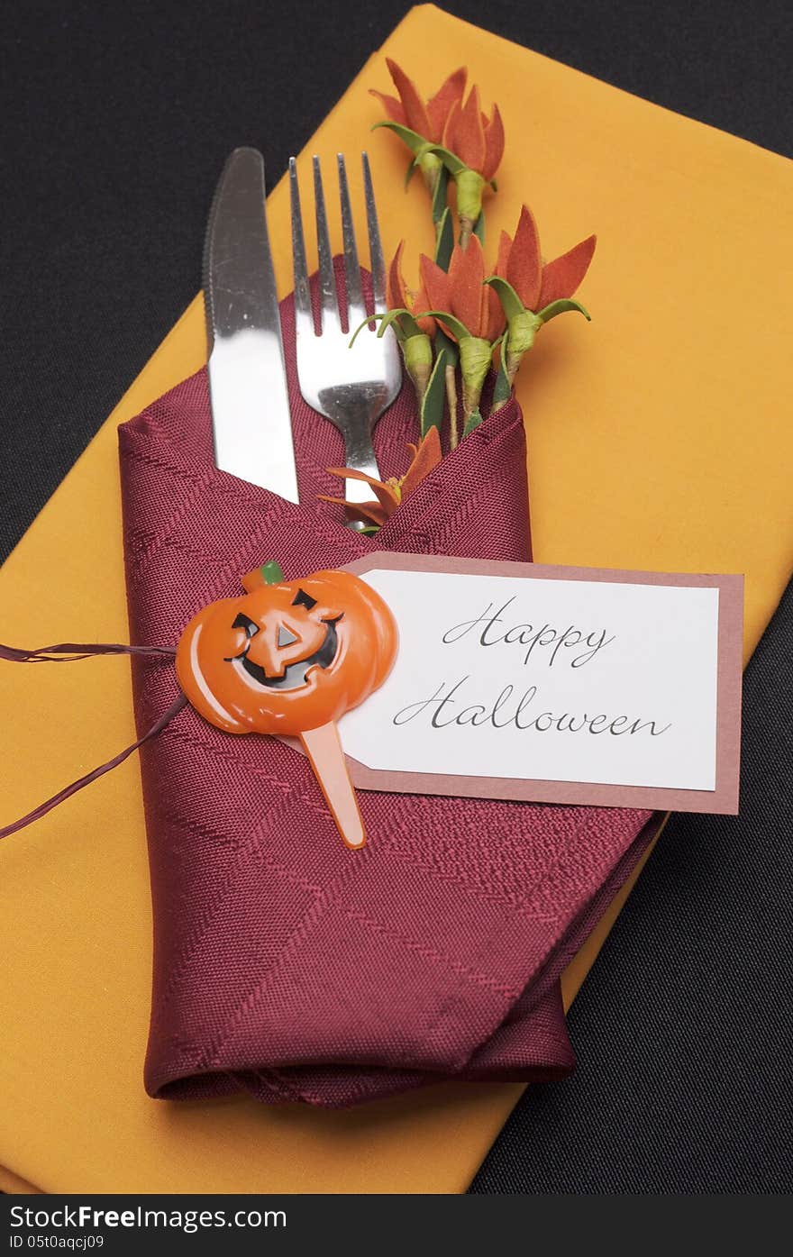 Happy Halloween table place setting with red and orange napkins - aerial.